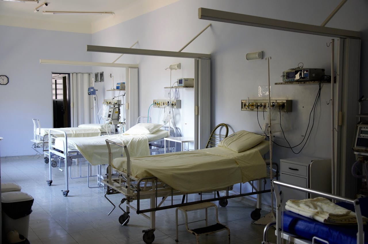 heros-img Spacious hospital room with several empty beds and medical equipment, emphasizing healthcare and hygiene.