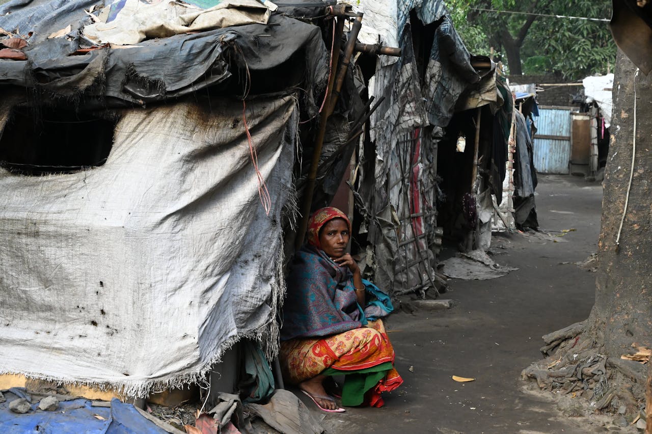 services-03 A woman sits outside a temporary shelter in a slum area of Chittagong, Bangladesh.