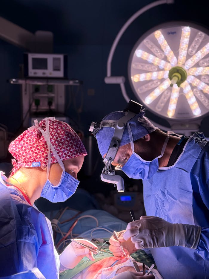 Two surgeons concentrate on a critical operation in a well-lit surgical room.